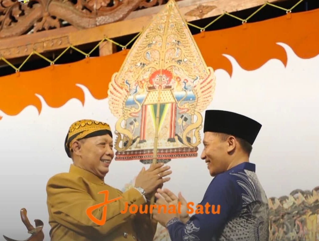 Wabup Tulungagung, Ahmad Baharudin, saat menyerahkan gunungan wayang kepada Dalang Ki Minto Sudarsono dalam acara Bersih Desa di Desa Ngrance, Kecamatan Pakel